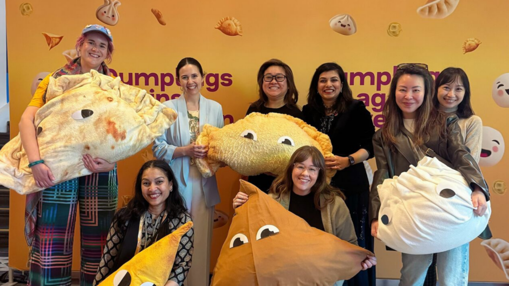 Smiling people hugging giant dumpling cushions at Dumplings Against Depression 2025